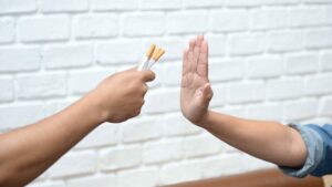 deux mains, l'une veut offrir des cigarettes, l'autre dit non