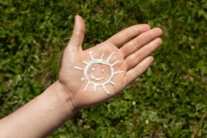 Una persona si è dipinta un cuore sulla mano con la crema solare