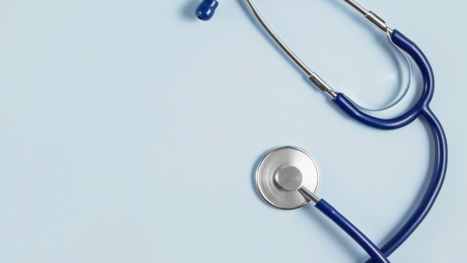 black and silver stethoscope on a light blue background