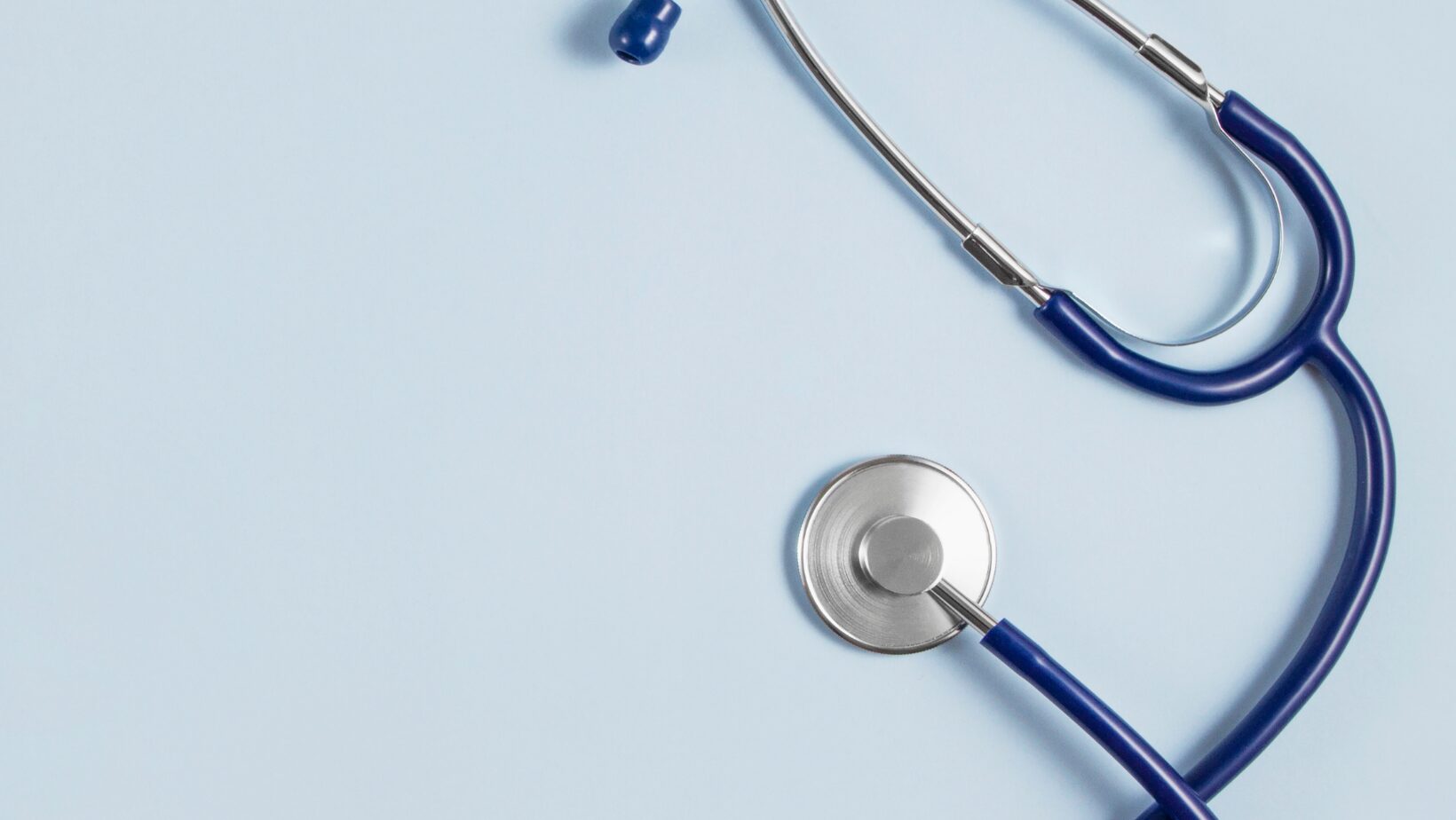black and silver stethoscope on a light blue background