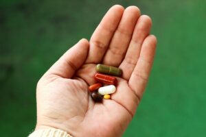 Various medications and pills in one hand