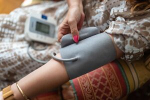 Woman measuring blood pressure with blood pressure monitor